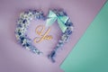 Heart made from hyacinths blossoms and mint bow on purple background with wooden letters You. Royalty Free Stock Photo