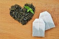 Heart made from leaf tea, tea bags and fresh mint leaves on wooden background Royalty Free Stock Photo