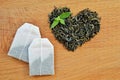 Heart made from leaf tea, tea bags and fresh mint leaves on wooden background Royalty Free Stock Photo