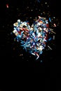 Heart made of multicolored festive shining sequins on a dark background
