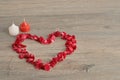 A heart made out of rose petals with a white candle Royalty Free Stock Photo