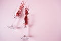 Heart made of pink and red beads pouring out from two transparent wine glasses on the pink background Royalty Free Stock Photo