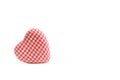 A heart made with red and white chequered fabric isolated on a white background