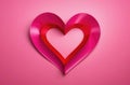 Heart made of ribbon on contrast pink background, Valentine\'s Day