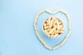 Heart made of Romanian pufuleti in white bowl over blue background Royalty Free Stock Photo