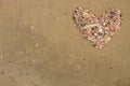 Heart made of sea shells lying on a beach sand