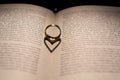 A heart made from the shadow of a ring on a book Royalty Free Stock Photo