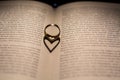 A heart made from the shadow of a ring on a book Royalty Free Stock Photo