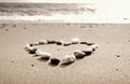 Heart made of small stones on sand Royalty Free Stock Photo