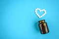 The heart made of tablets, medical thermometer on blue background Royalty Free Stock Photo