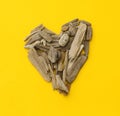 Heart made of wooden sticks on a yellow background. Royalty Free Stock Photo