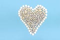 Heart madinf of pills, capsule, tablet on blue background with space for text. Concept of coronavirus in color of year Royalty Free Stock Photo