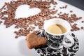 Heart make whit coffee beans and cup whit espresso and sweet heart cookie on white table background.