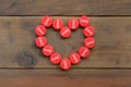 Heart of many red caps with coca cola logo on wooden background Royalty Free Stock Photo