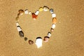 Heart of multi-colored stones on a sandy beach. Close-up. Background. Space for text Royalty Free Stock Photo
