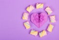 Heart origami and marshmallow on a gentle purple background.