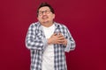 Heart pain attack or infarct. Portrait of middle aged man in casual checkered shirt and eyeglasses standing and holding his