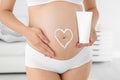 Heart painted with body cream on pregnant woman`s Royalty Free Stock Photo