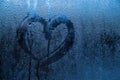 Heart painted on misted glass. Valentines day, love symbol on frozen glass in winter. Royalty Free Stock Photo