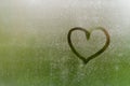 Heart painted on window which fogged up after rain