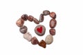 A heart of pebbles surrounds a pebble with a red heart