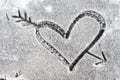 Heart pierced by an arrow drawn with the snow