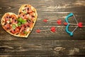 Heart pizza love concept Valentines day romantic dinner Italian pastry with cupid onions. on a wooden table. Flat-lay