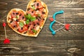 Heart pizza love concept Valentines day romantic dinner Italian pastry with cupid onions. on a wooden table. Flat-lay