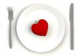 Heart on plate, knife and fork on white table