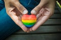 Decorative Heart with rainbow stripes in female hands. LGBT pride flag, symbol of lesbian, gay, bisexual, transgender for social