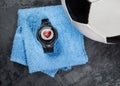 Heart rate monitor on blue towel near soccer ball