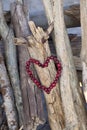 Heart of red berries hanging on some driftwood