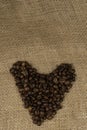 Heart with roasted coffee beans on the burlap background Royalty Free Stock Photo