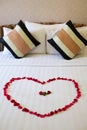 Heart of rose petals laid out on the bed Royalty Free Stock Photo