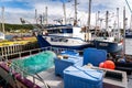 Heart\'s Content Newfoundland Canada, September 26 2022: Fishing boats moored at a dock with fish nets and storage bins Royalty Free Stock Photo