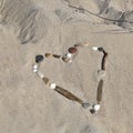 Heart of sea shells and driftwood in the sand Royalty Free Stock Photo