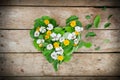 Heart shape arrangement made of leaves and flowers on table Royalty Free Stock Photo