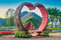 Heart shape bamboo arch in photo zone of flower garden with mountain background