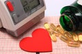 Heart shape, blood pressure monitor and tablets on electrocardiogram Royalty Free Stock Photo