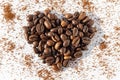 Heart shape from brown roasted coffee beans Robusta, Arabica coffee on a background of ground coffee on a white Royalty Free Stock Photo