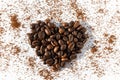 Heart shape from brown roasted coffee beans Robusta, Arabica coffee on a background of ground coffee on a white Royalty Free Stock Photo