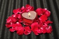 A heart shape candle with rose petals