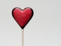 Heart shape chocolate lollipop with red color and heart stamp isolated over white background