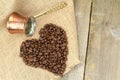 Heart shape with coffee beans and traditional Turkish copper coffee pot on a burlap Royalty Free Stock Photo