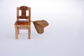 Heart shape cut dry leaf put on a little model chair as an autumn background
