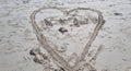Heart shape drawn in the sand of the beach. Love Royalty Free Stock Photo