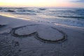 Heart shape drawn on sand on beach at sunset Royalty Free Stock Photo