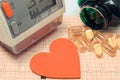 Heart shape, blood pressure monitor and tablets on electrocardiogram. Healthy lifestyles Royalty Free Stock Photo