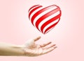 Heart shape are floating on open woman hand on pink background