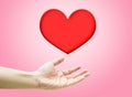 Heart shape are floating on open woman hand on pink background